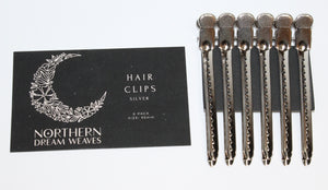 6 metal hair clips with branded card on a mantle with brick background